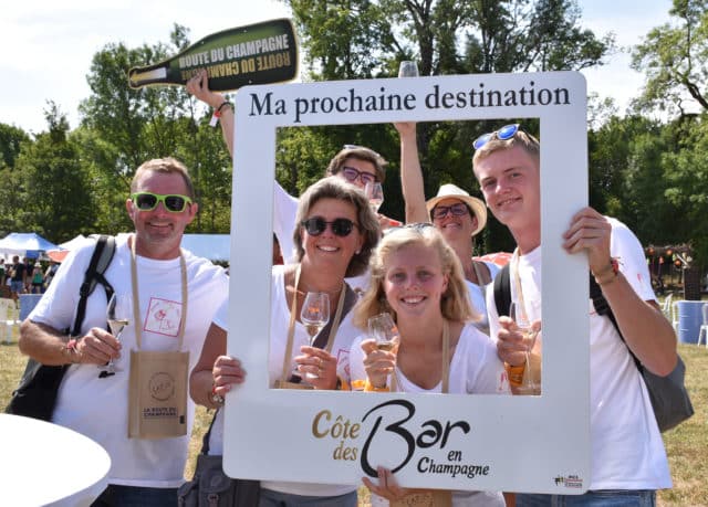 Personnes tenant un cadre photo et une pancarte Route du champagne en 2022